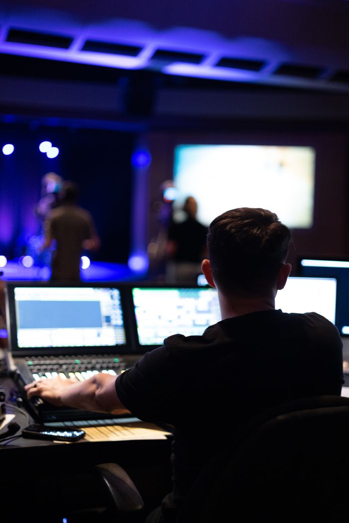 Sound engineer working at mixing console during a live studio performance.